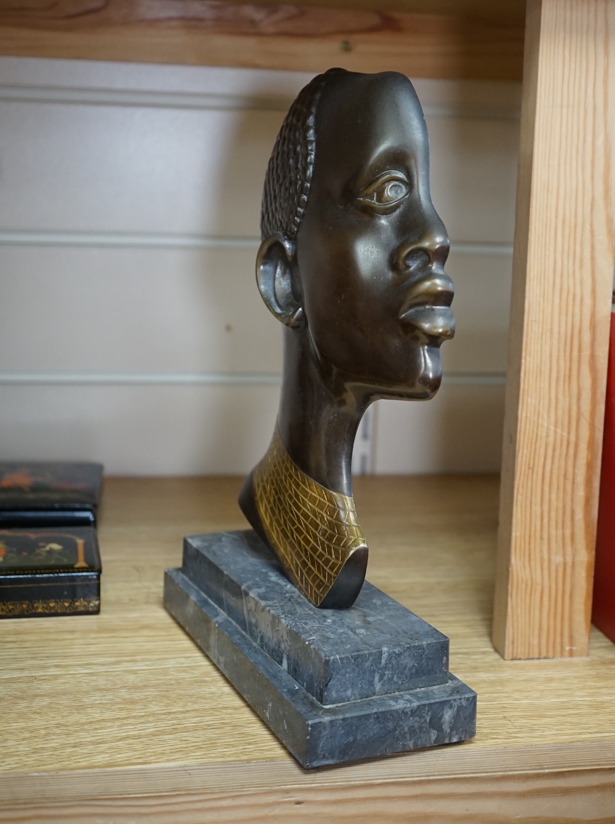 An Art Deco Hagenauer style bronze study of an African lady, stepped marble base, 28cm. Condition - earring missing